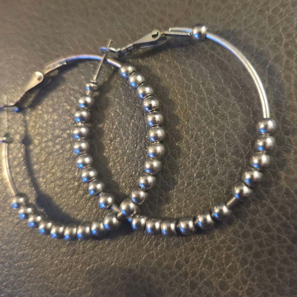 Silver toned hoop earrings with moving beads.